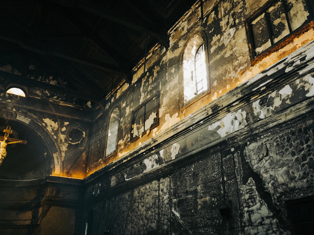 Interior of a damaged, old church with sunlight.