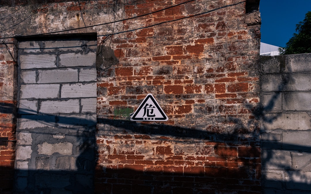 Warning sign on a weathered brick wall