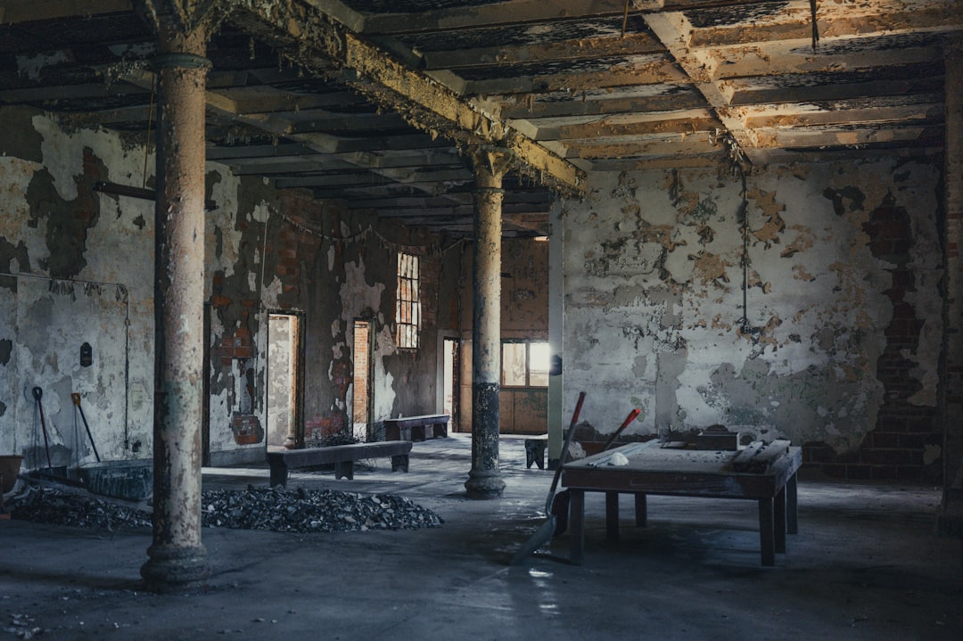 Abandoned room with decaying walls and wooden furniture.