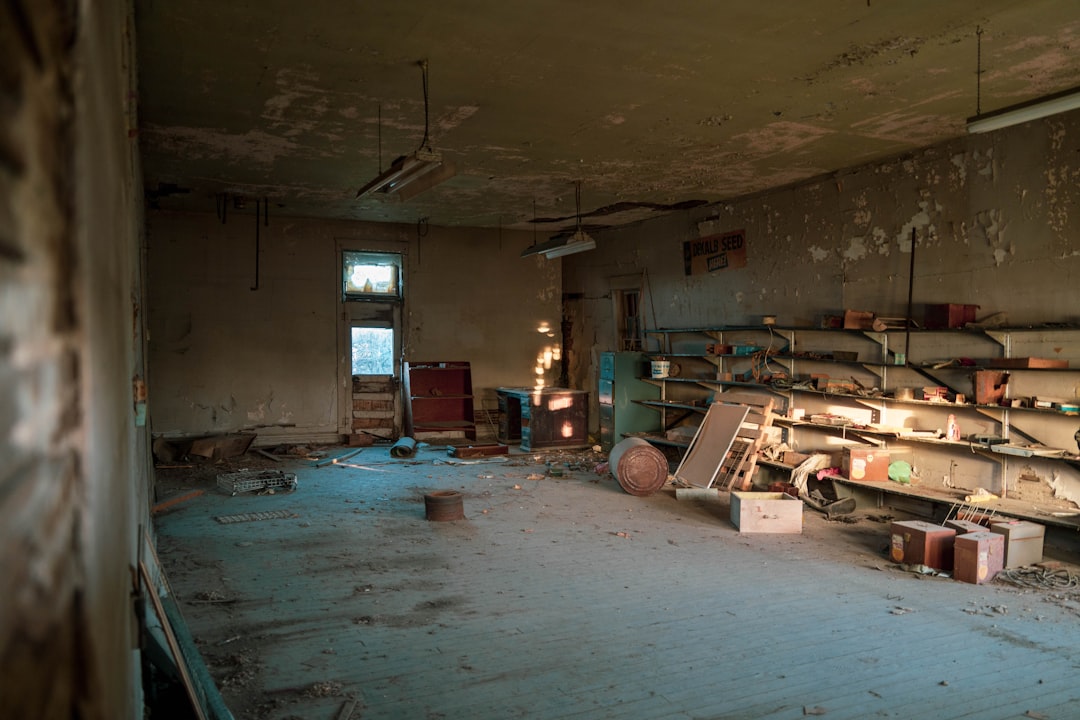 Dilapidated abandoned room with debris and sunlight from a window.